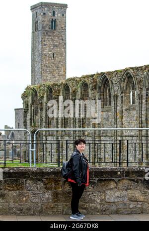 St Andrews, Fife, Scotland, UK. 3rd July, 2021. UK Weather: A cool misty day across North East Scotland with temperatures reaching 15°C. An American female tourist takes the day out to be photographed while sightseeing at the 1400`s Cathedral ruins in St Andrews. Credit: Dundee Photographics/Alamy Live News Stock Photo